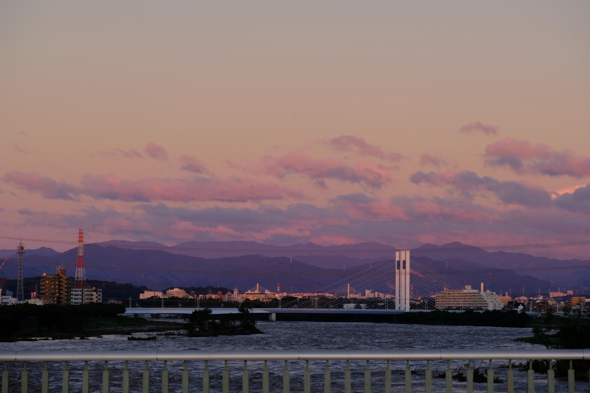 稲城大橋から望む増水した多摩川と朝の空